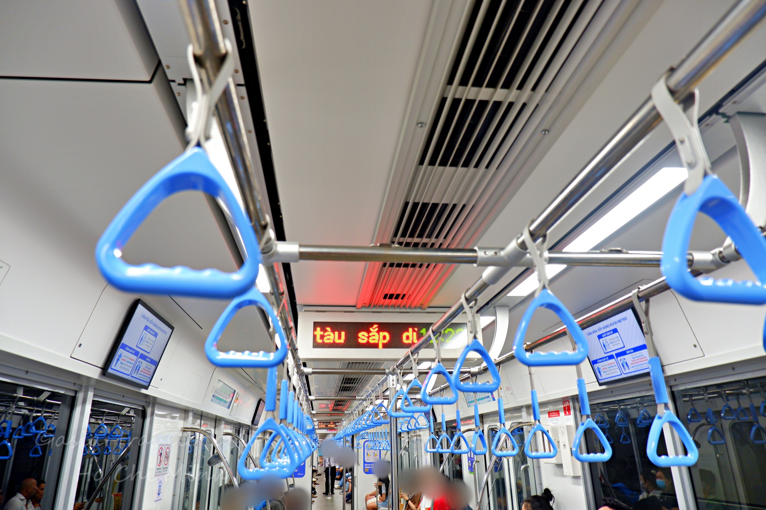 ホーチミンメトロ車内の青いつり革とLED表示板